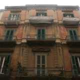 Foto 15. Su via Calefati al contrario si erge un imponente ma invecchiato palazzo a tre piani di un rosso ormai spento, che si caratterizza comunque per le particolari lesene che percorrendo la parte centrale, terminano in un cornicione floreale 